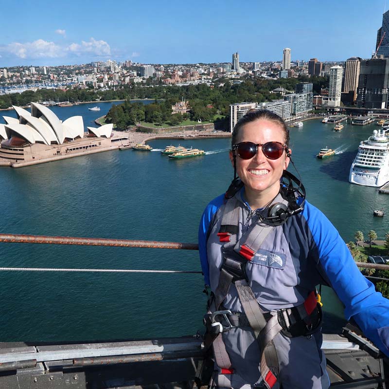 Woman in climbing gear with the Sydney cityscape in the background
